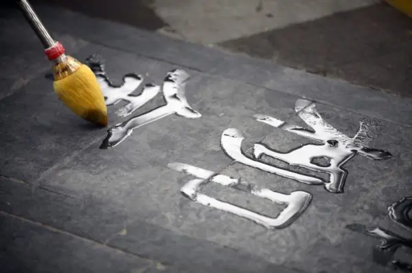 Chinese calligraphy painted with water on the sidewalk.